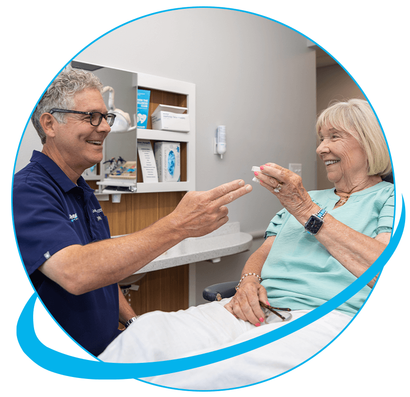Doctor showing a model of dental implants to Paitent